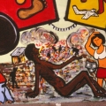 “Il Treno dei diritti va troppo lento” Mural alla Scuola Media “Carlo Levi” (Scampia, Napoli), 1999. Lo sfruttamento sessuale delle bambine e le tante Korogocho del mondo (particolare).