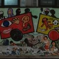 “Il Treno dei diritti va troppo lento” Mural alla Scuola Media “Carlo Levi” (Scampia, Napoli), foto del 2009. Vista d’insieme (fotomontaggio). Ph. Francesco Di Martino.</em&g
